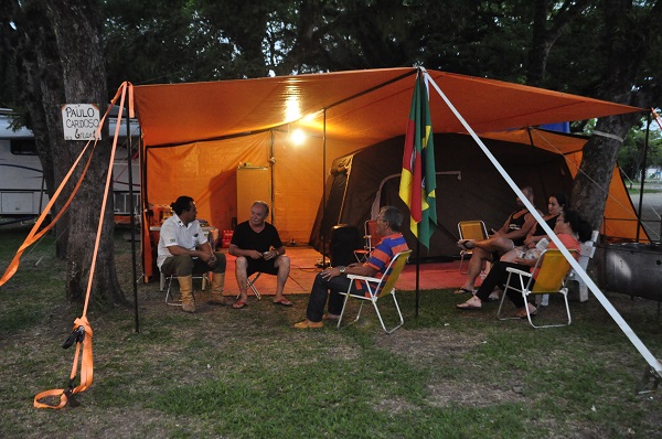 Coordenador dos acampamentos, Paulo Cardoso (ao lado das bandeiras), recebe os visitantes e orienta quem vai acampar