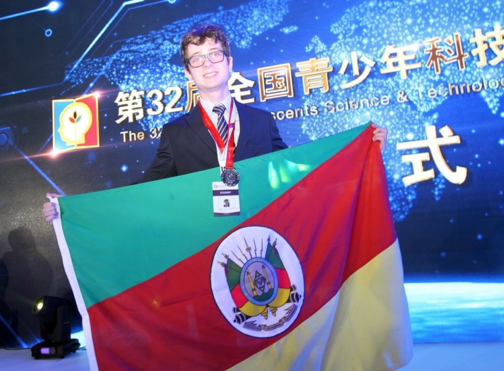 Pedro Kopper com a bandeira do RS e a medalha de prata conquistada na China 