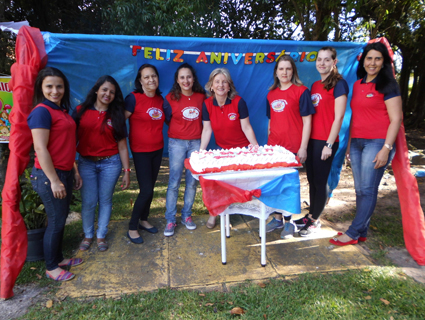 Diretora Marguit Morais, atrÌÁs do bolo, junto ÌÊs demais funcionÌÁrias na comemoraÌ¤Ì£o dos 28 anos da Escolinha ParaÌ_so Infantil